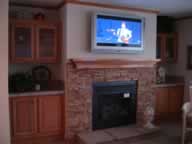 Half stone fireplace, wood mantel, and wall mount tv